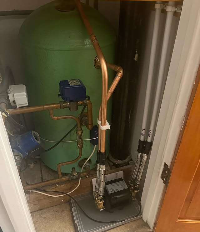 Water pump fitted beside a hot water cylinder